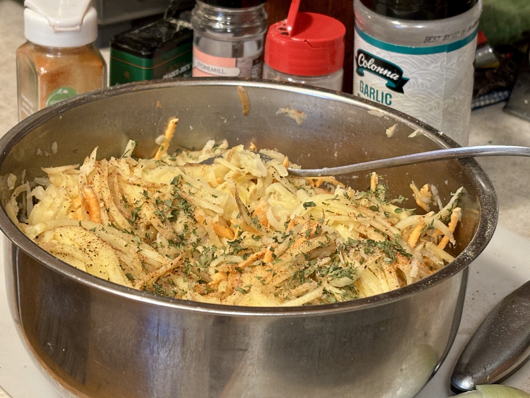 Hash Browns in bowl with spices used shown behind